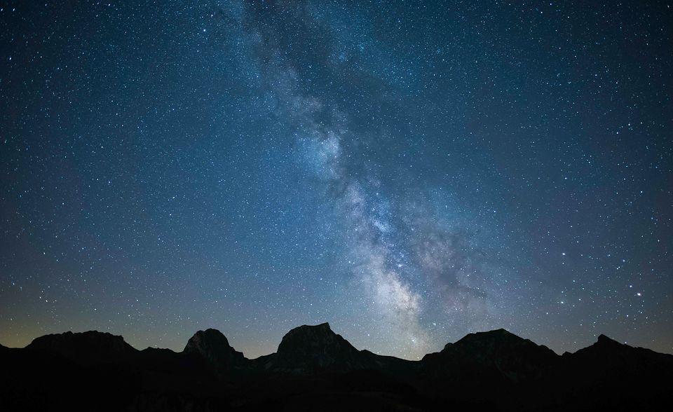 Un ciel la nuit avec des montagnes