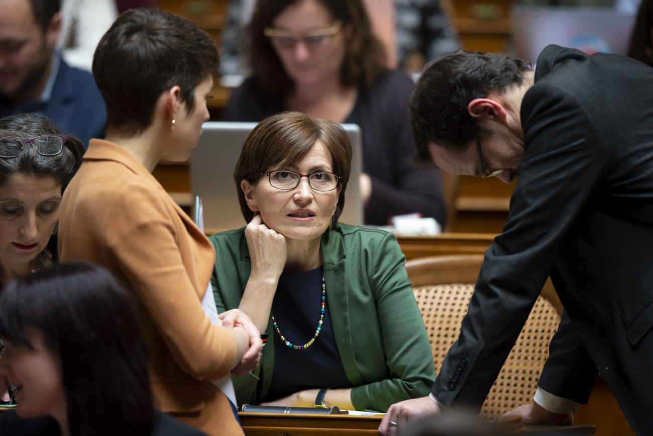 Trois personnes parlent dans une salle