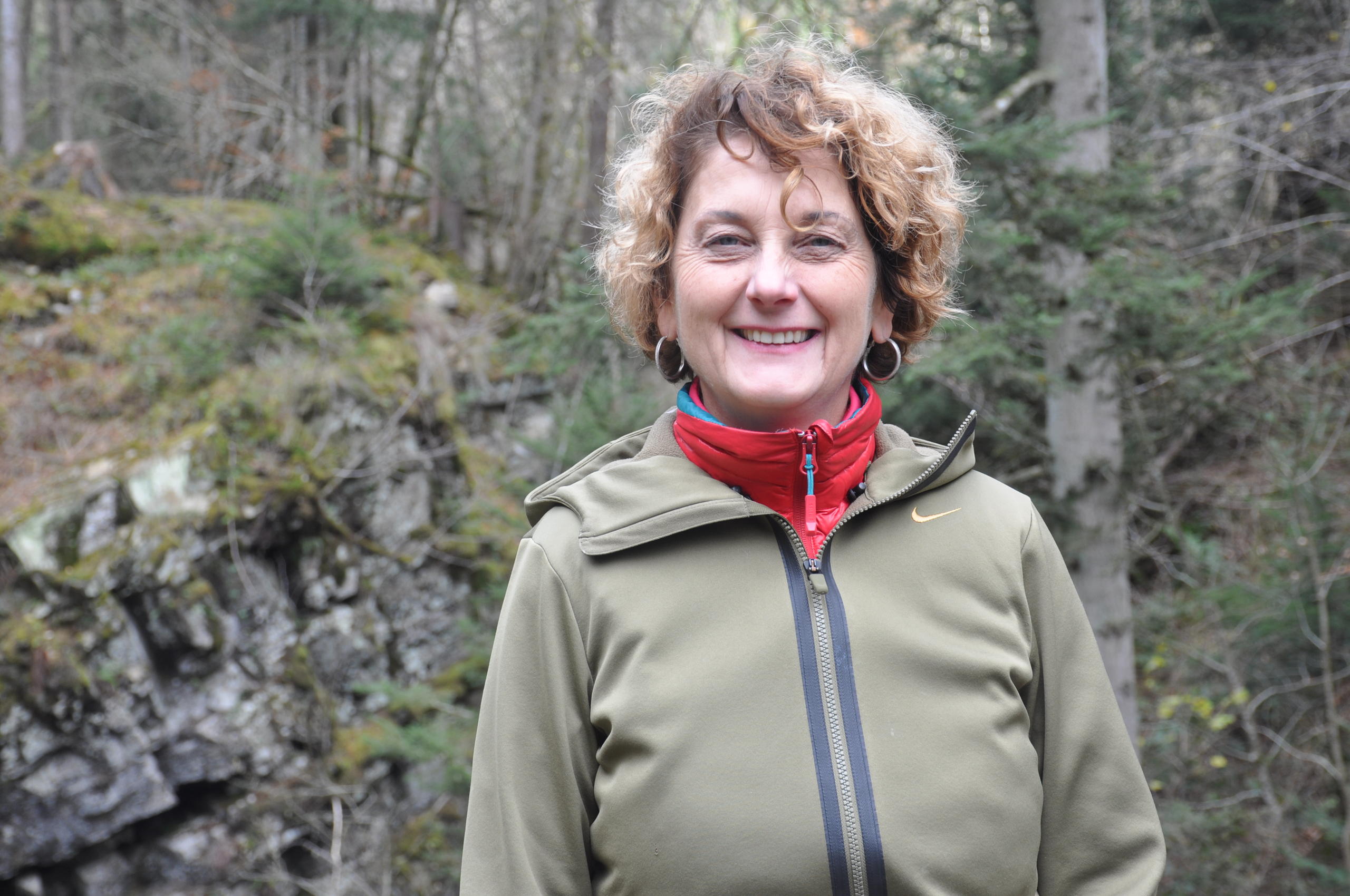 Marianne Maret in front of trees and rocks