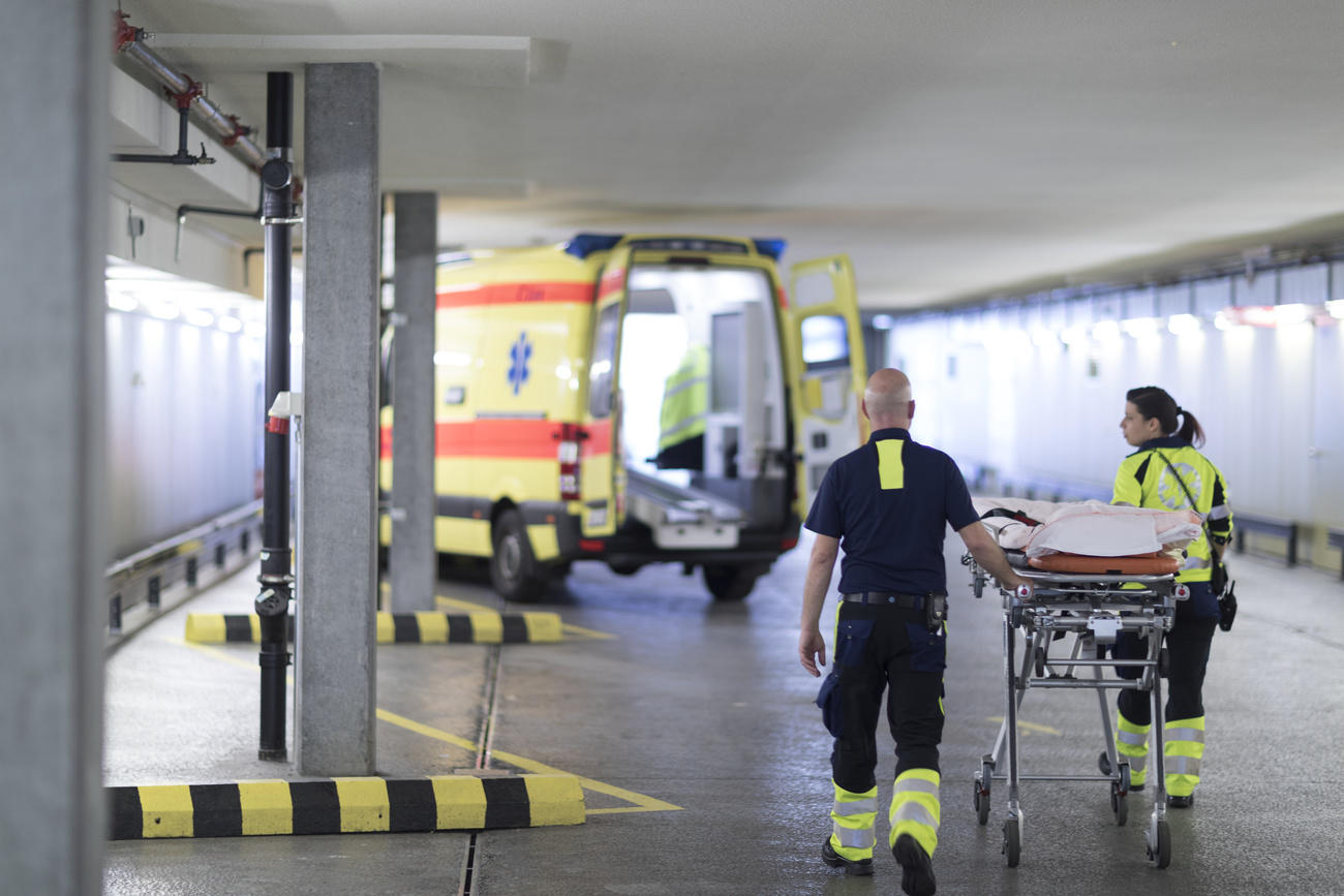 Due paramedici con la barella stanno andando verso l ambulanza.