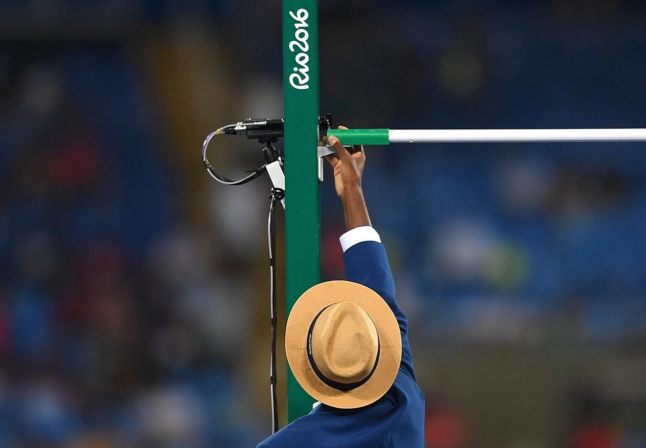 High jump bar being adjusted