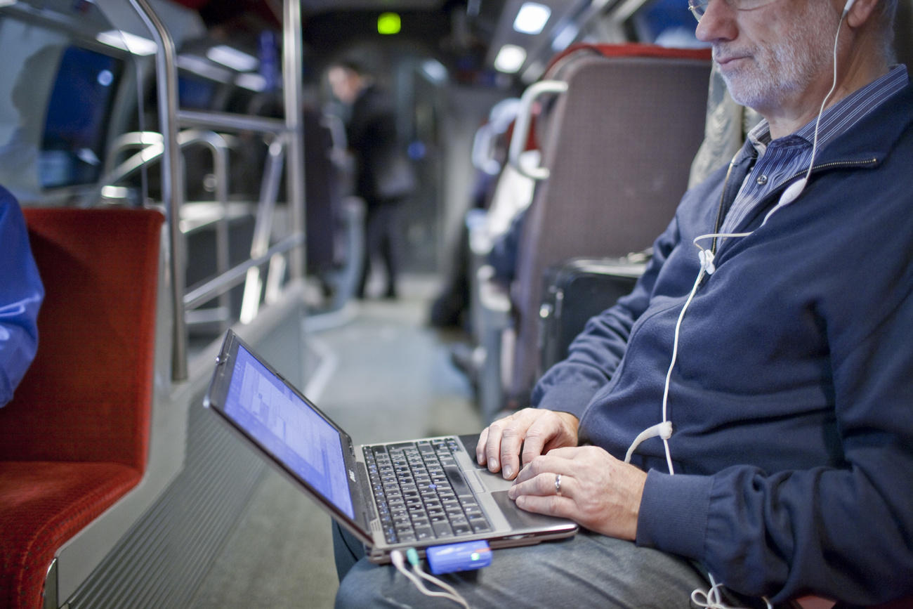 A man working on his laptop on the train