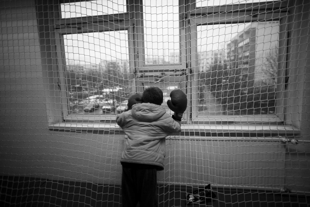 Un niño apoyado en una ventana