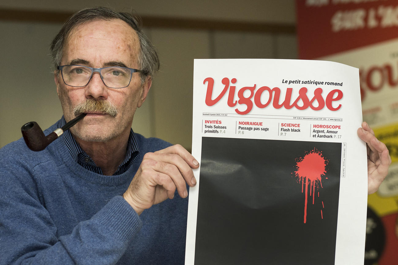 Un hombre ssstiene la portada de una revista en la que se aprecia un una mancha roja