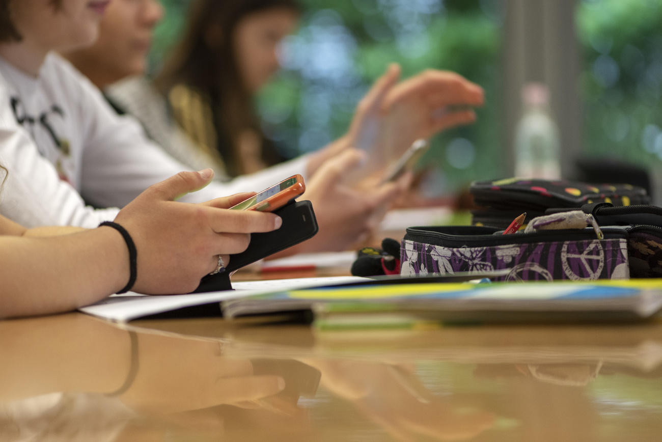 Des jeunes à l école avec dans les mains des téléphones portables