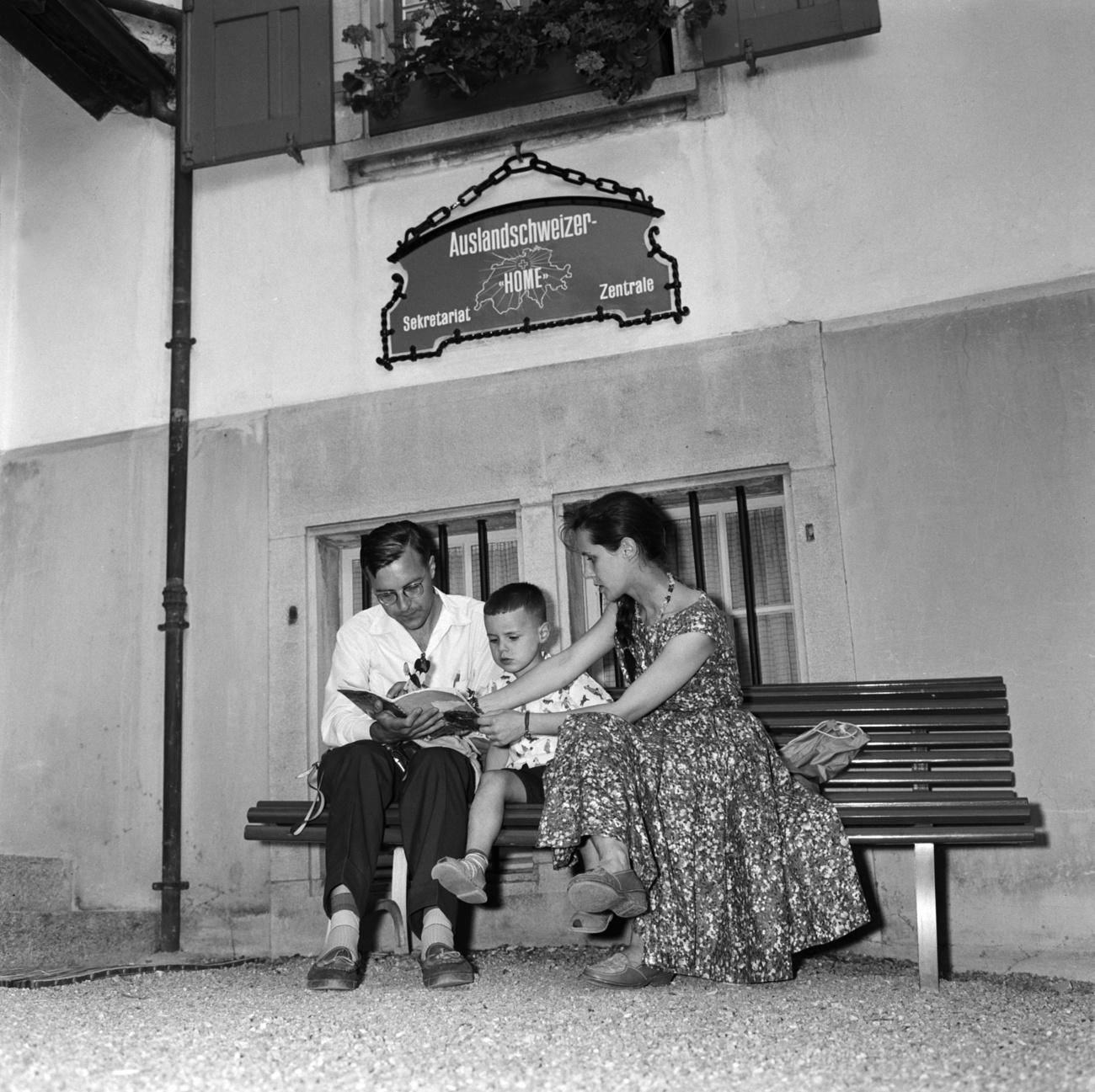 Une jeune famille assise devant le Foyer des Suisses de l étranger