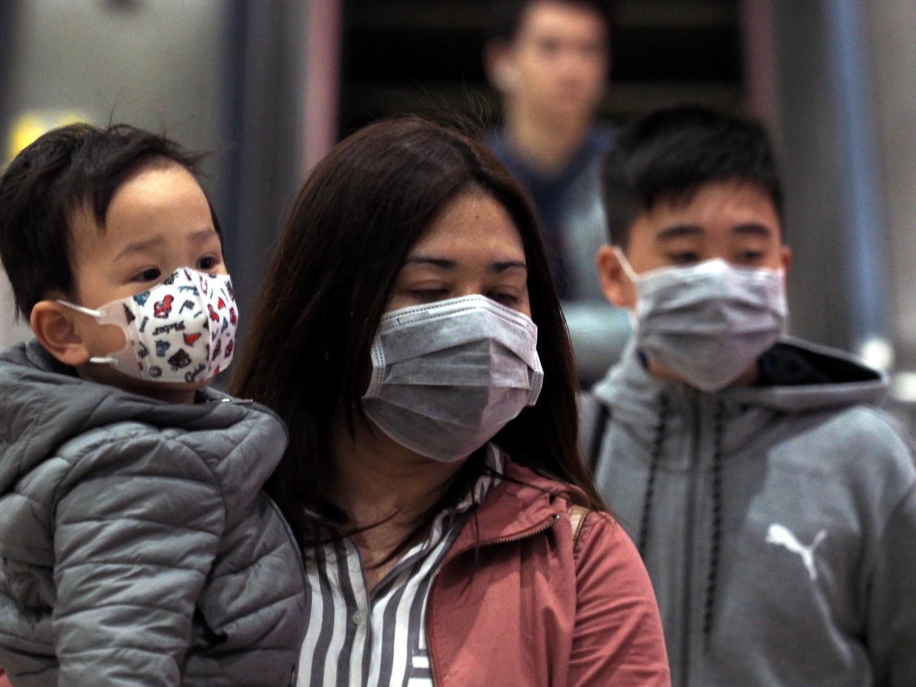 Familia asiática: Una mujer, un bebé y un niño con mascarillas