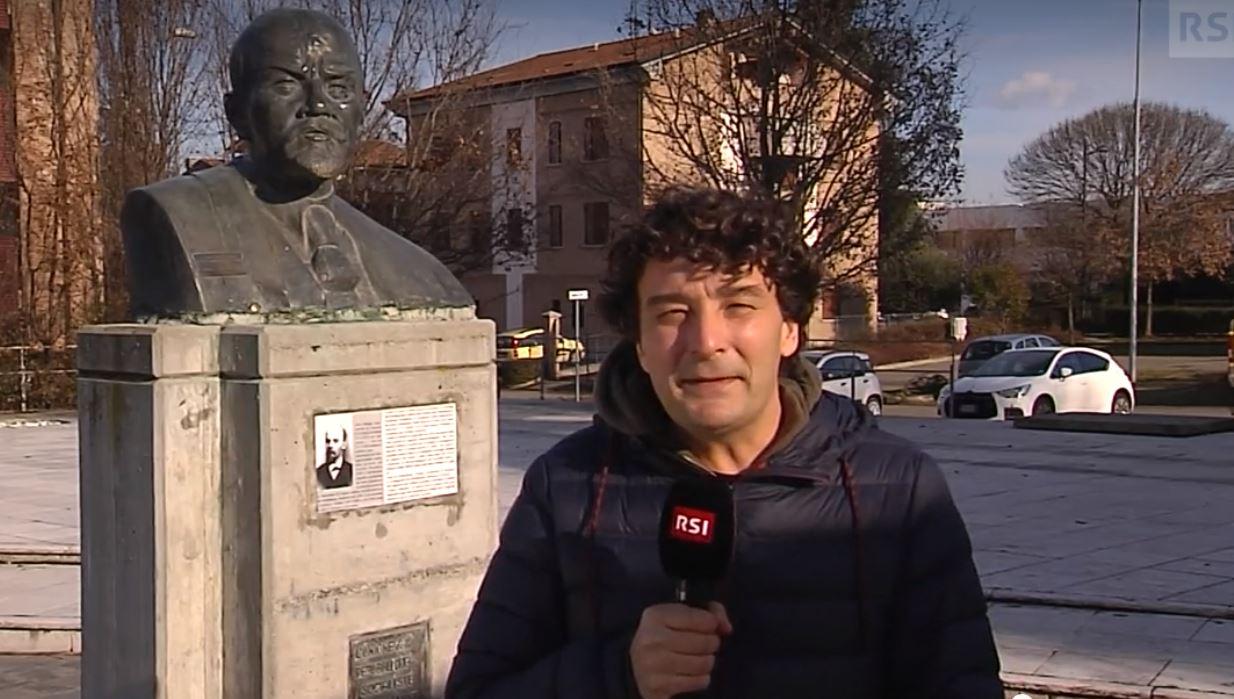 Persona con microfono sotto busto di Lenin