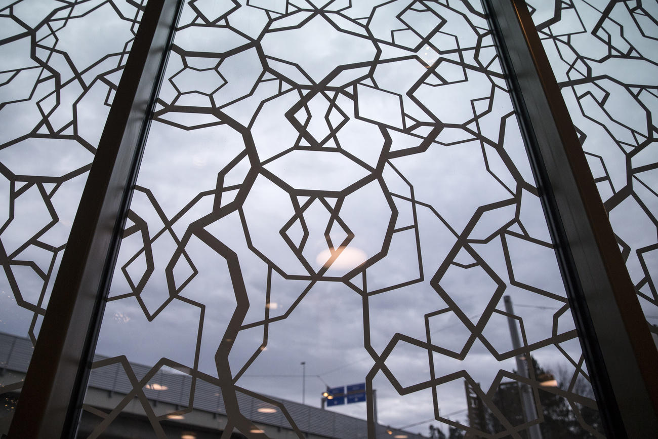 Vetrata a mosaico i cui giunti richiamano vagamente i simboli delle religioni più diffuse