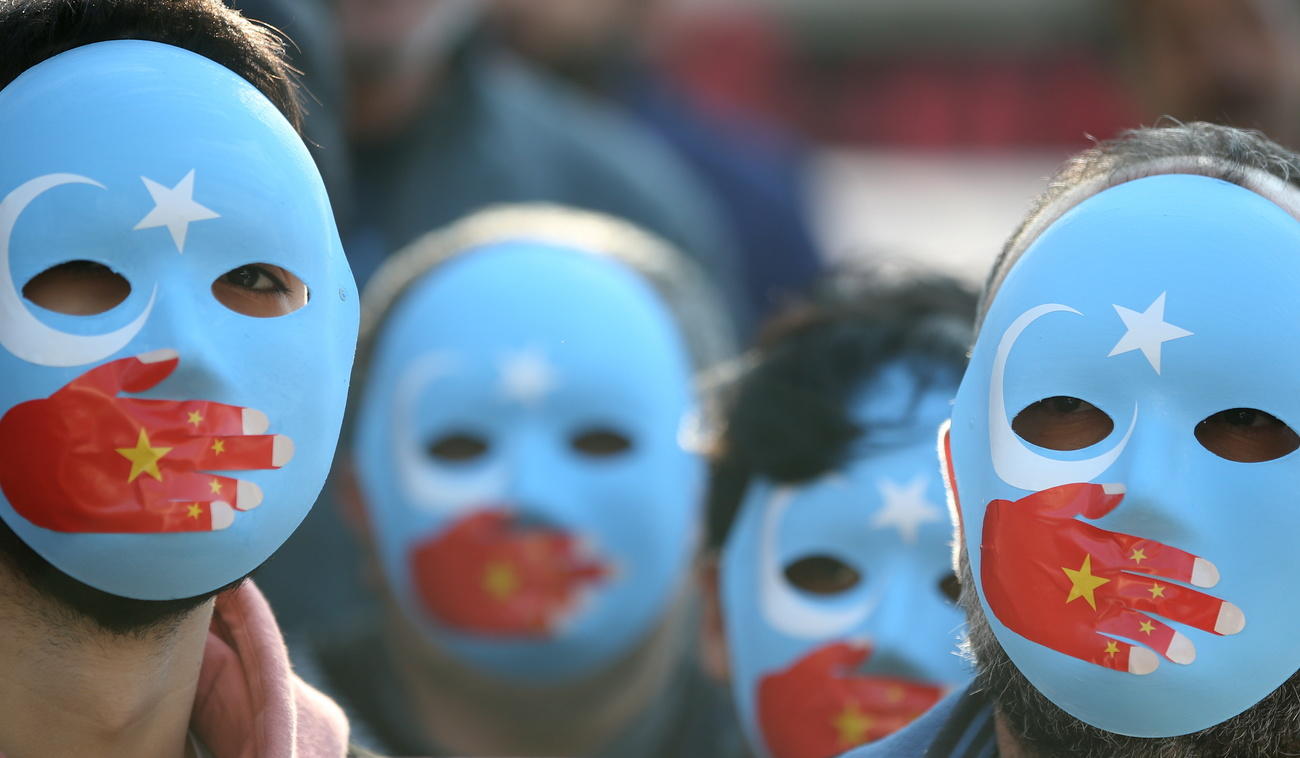 manifestanti con una maschera con la bandiera cinese che tappa la bocca