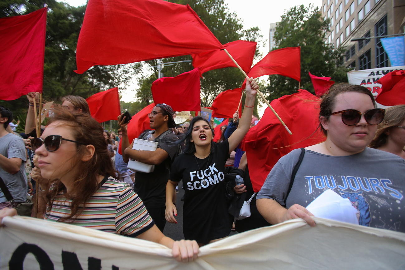 Manifestanti a Sydney contro il governo australiano che non farebbe nulla contro i cambiamenti climatici.