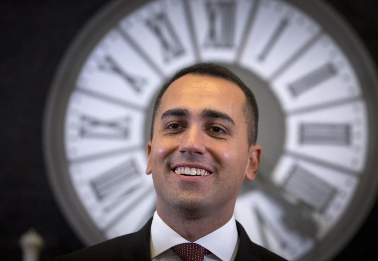 Di Maio sorridente davanti a un orologio