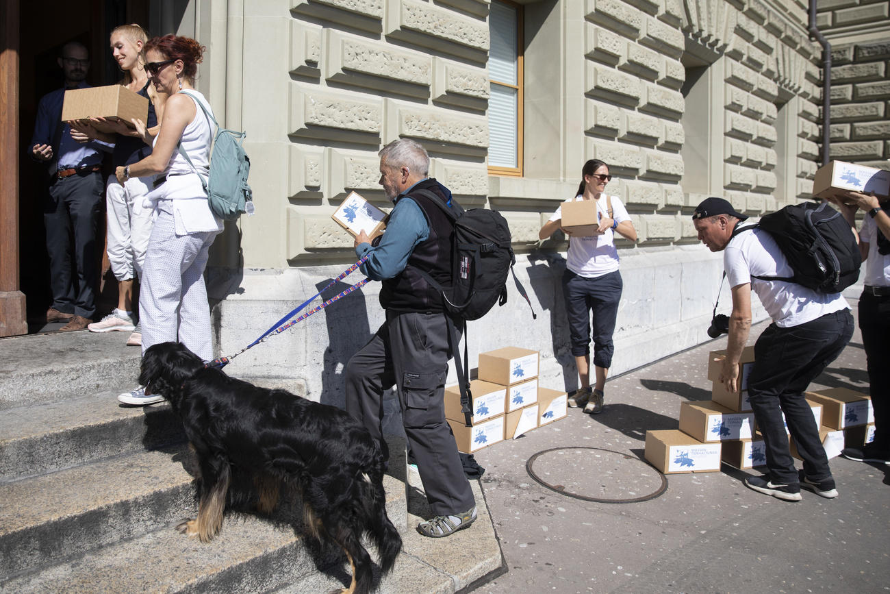 Campaigners with dog carrying boxes inside a building