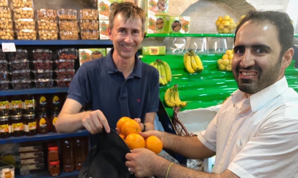 мужчина покупает апельсины