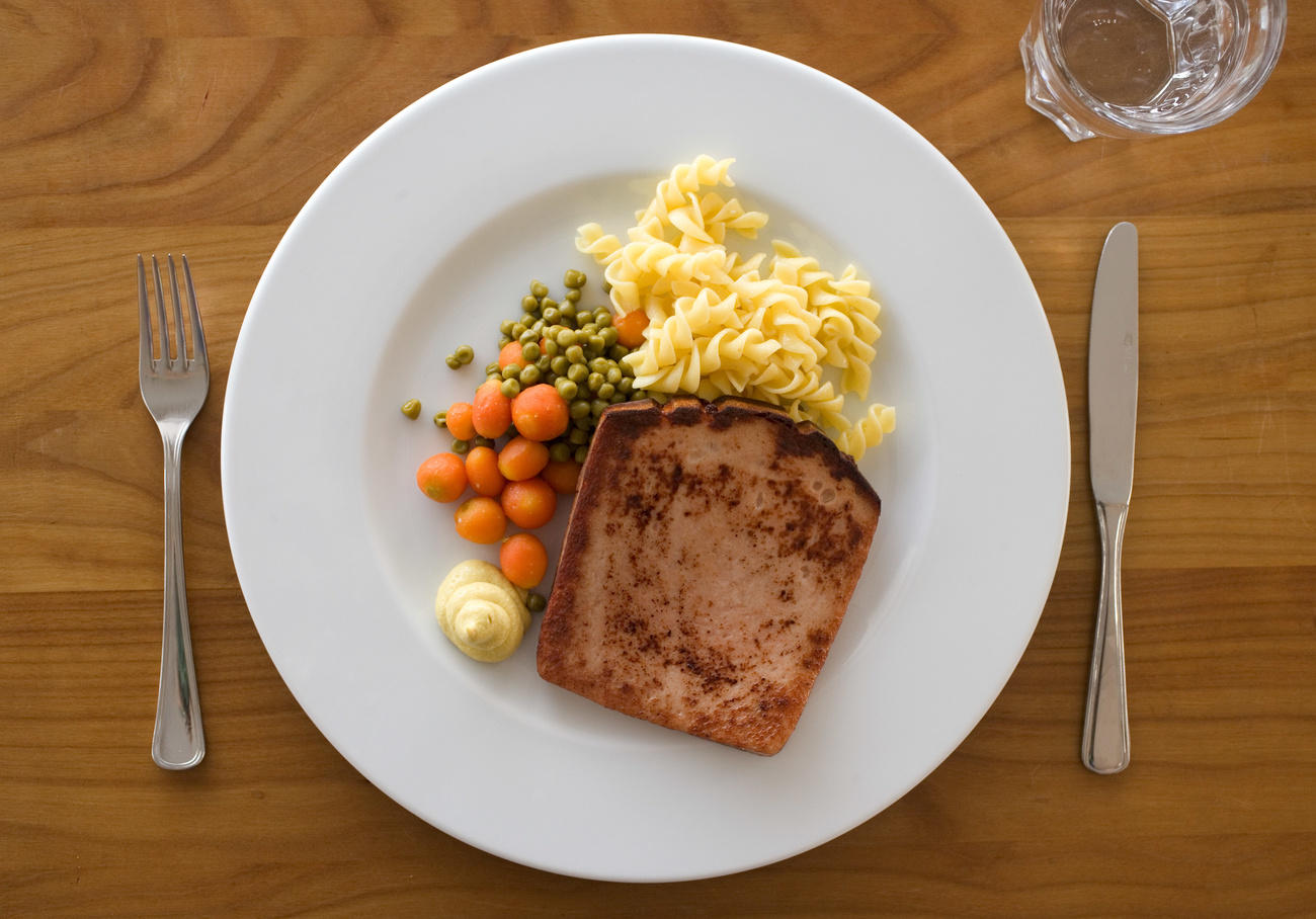 Un piatto di Fleischkäse con pasta e contorno di verdure