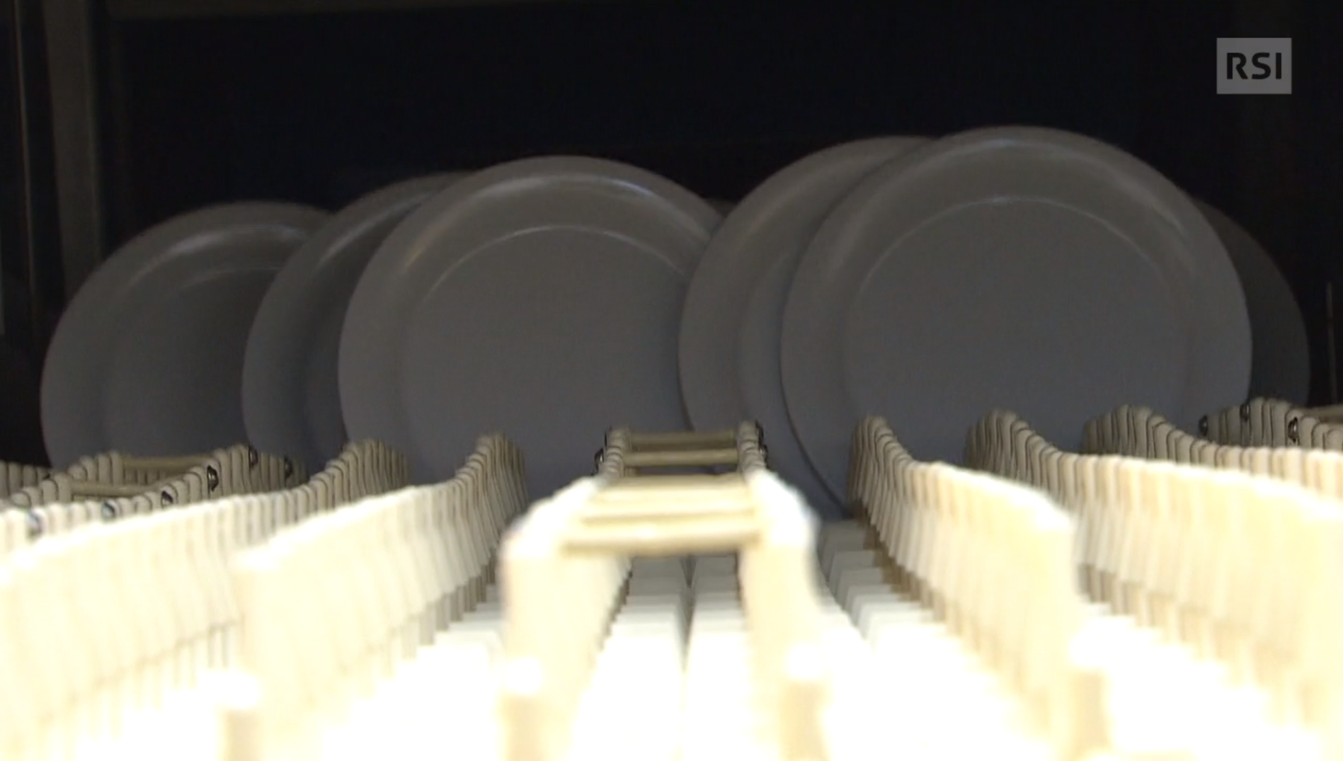 Immagine di piatti, apparentemente in porcellana, su una griglia tipo cestello di lavastoviglie.