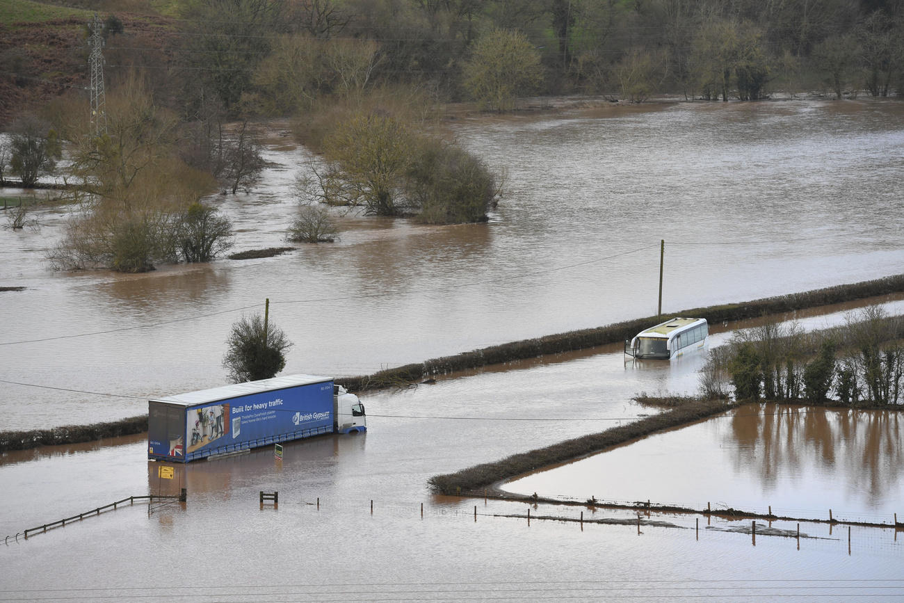 Un camion e un bus completamente travolti dalle acque di un fiume esondato.