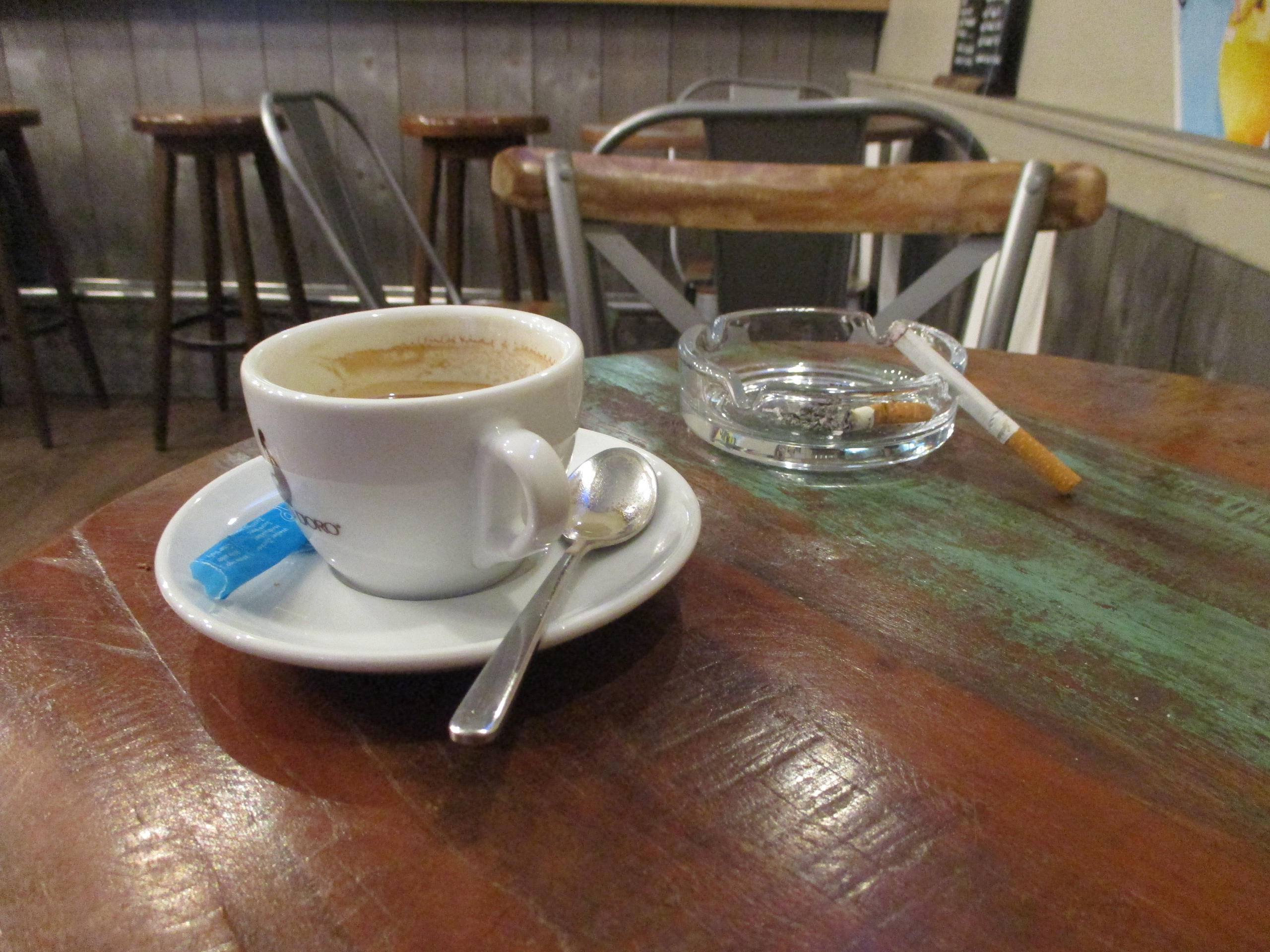 Cendrier et tasse de café sur une table.