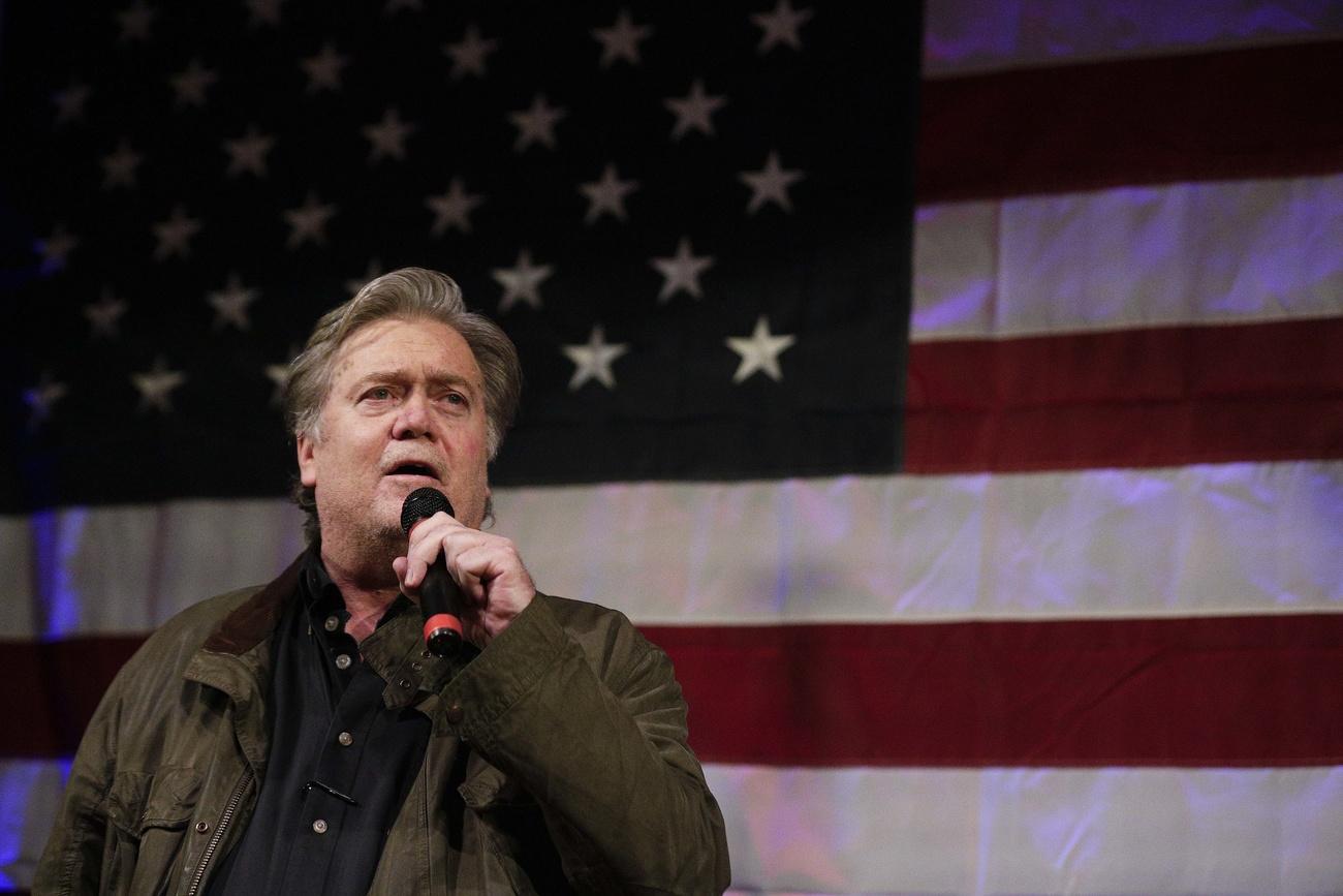 Steve Bannon durante un discorso con la bandiera americana dietro la schiena