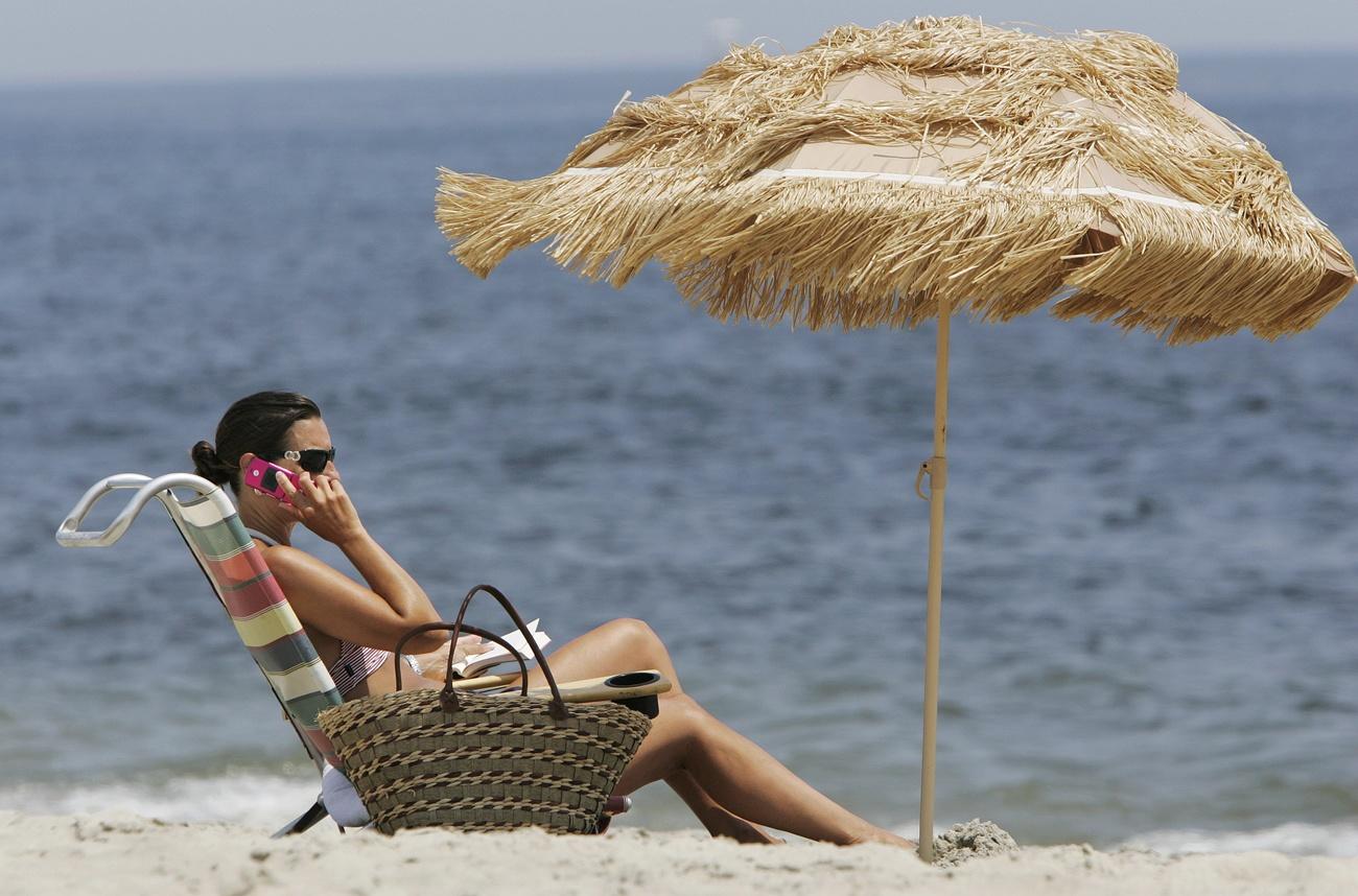 Woman on beach using phone