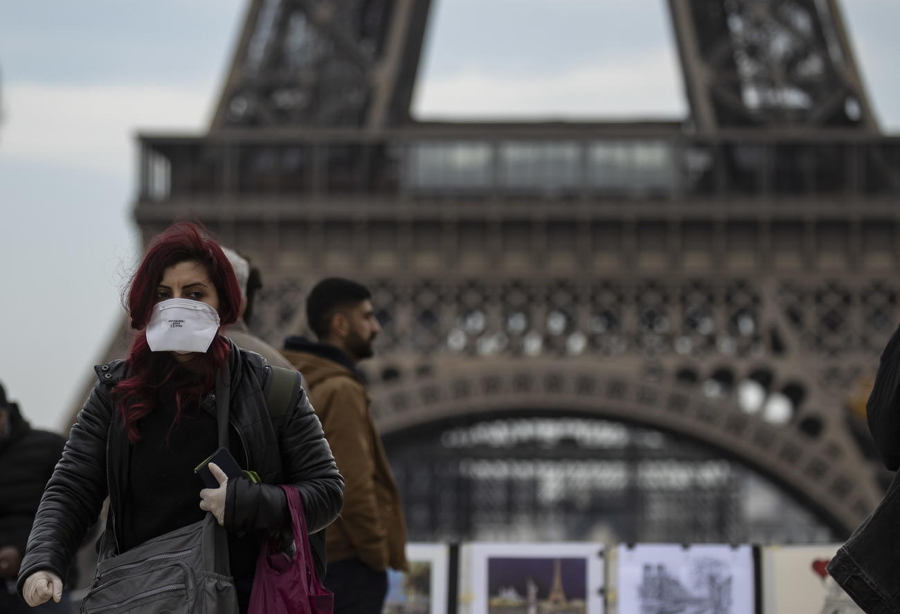 A woman wears a protective face mask near the Eiffel Tower, in Paris, France, 15 February 2020.