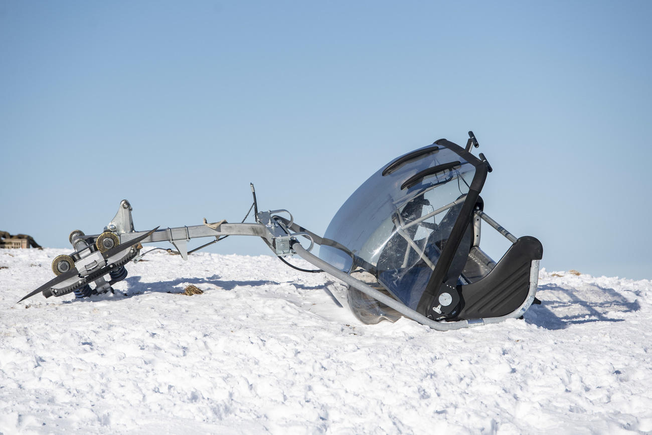 The broken chairlift sits on the snow