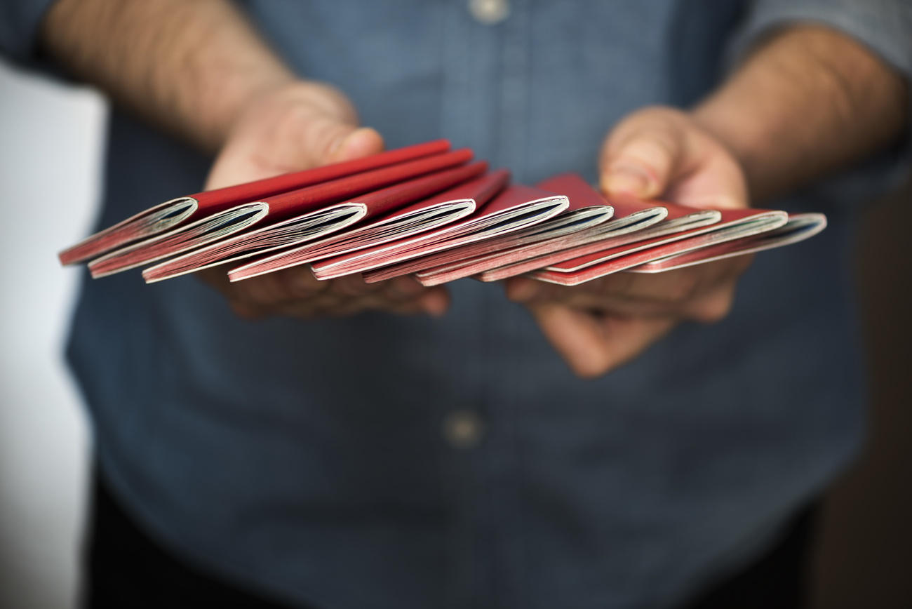hands of a man holding several swiss passports