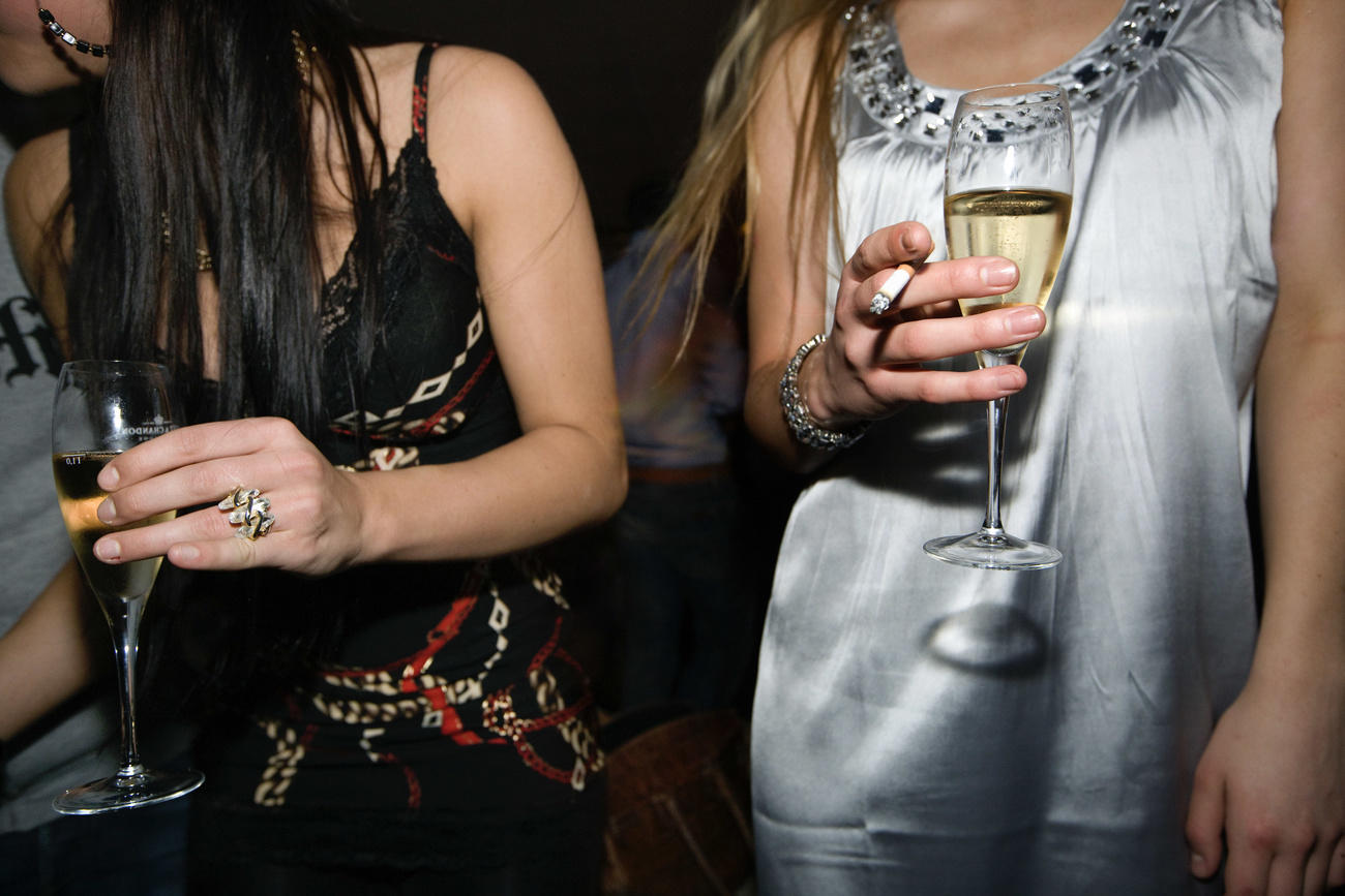 two women with drinks and cigarettes