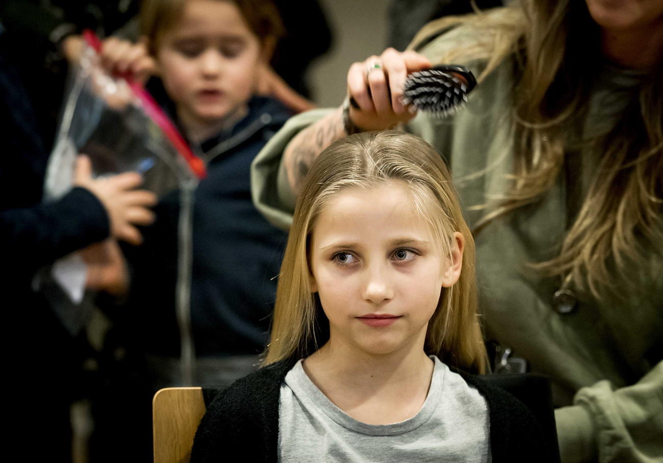 Una bimba che deve tagliarsi i capelli dopo la chemioterapia