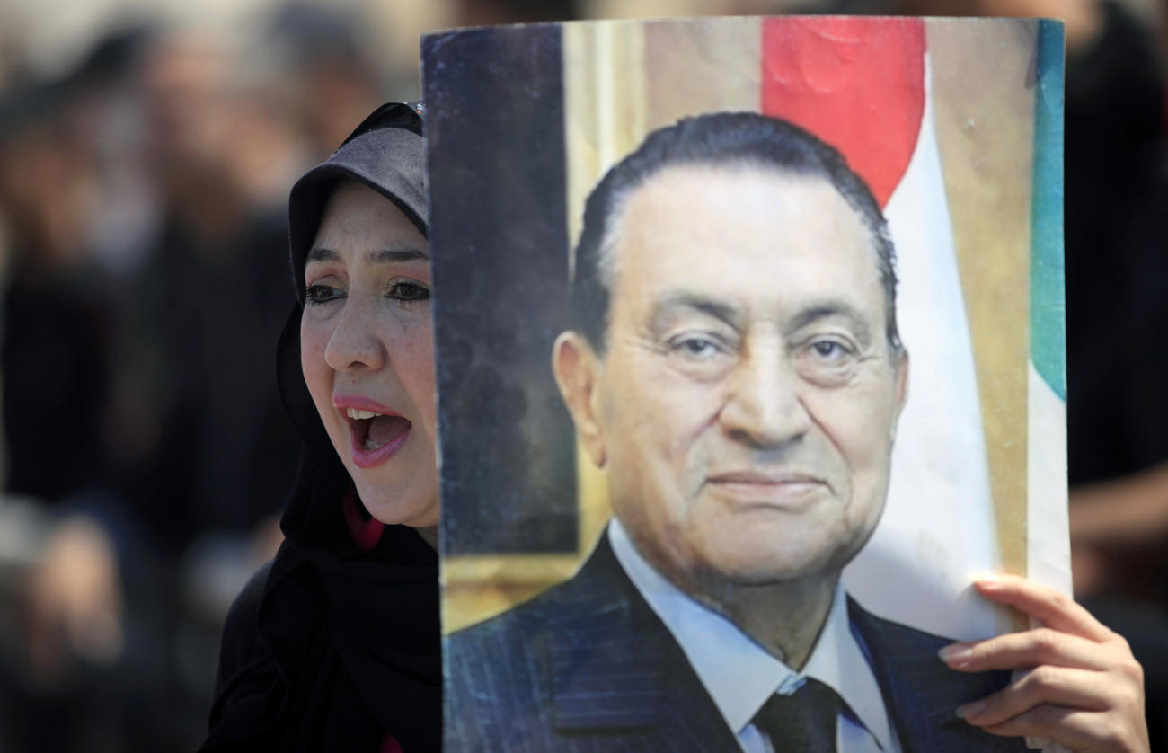Un ritratto di Mubarak mostrato da una sua sostenitrice nel 2013 durante i processi contro l ex presidente.