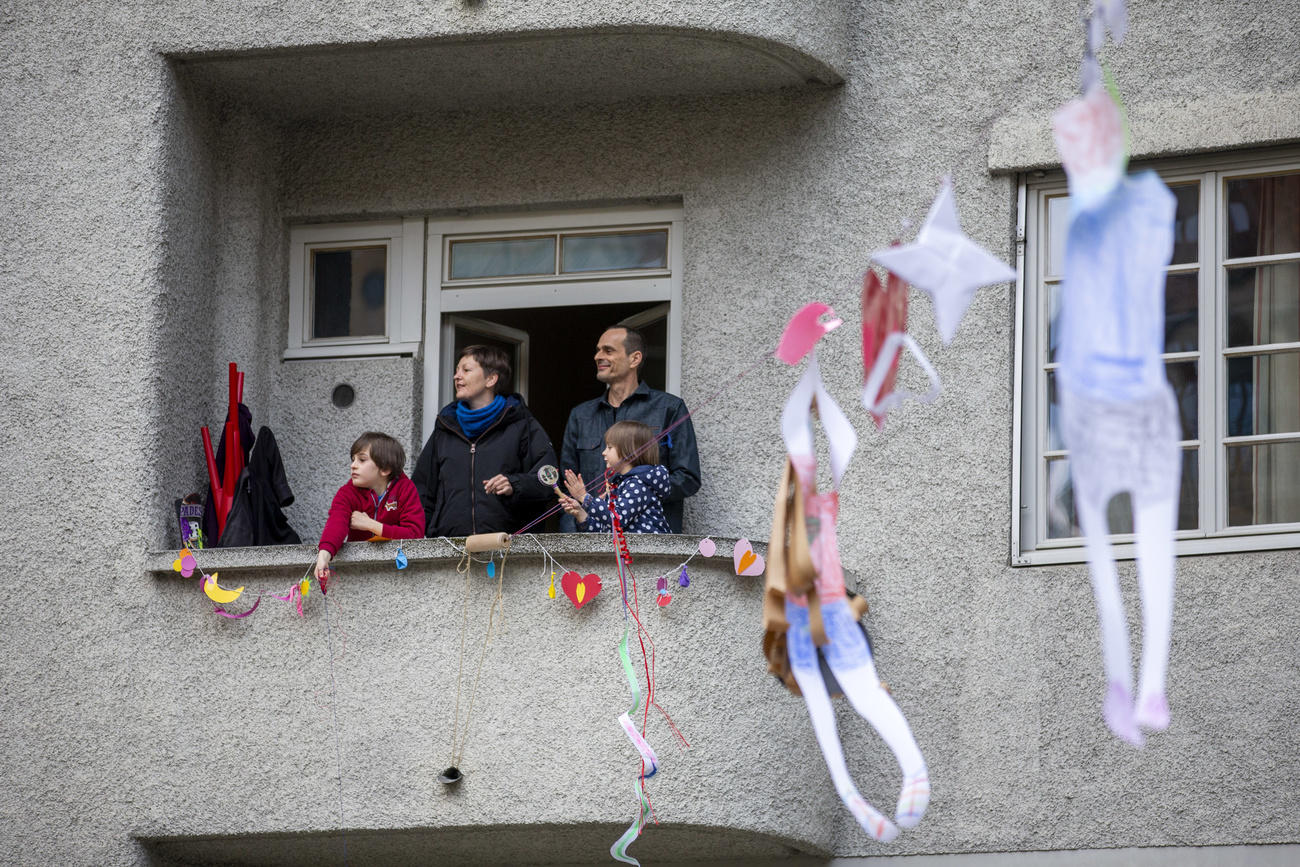 مواطنون سويسريون في شرفة شقتهم أثناء تفشي جائحة فيروس كورونا