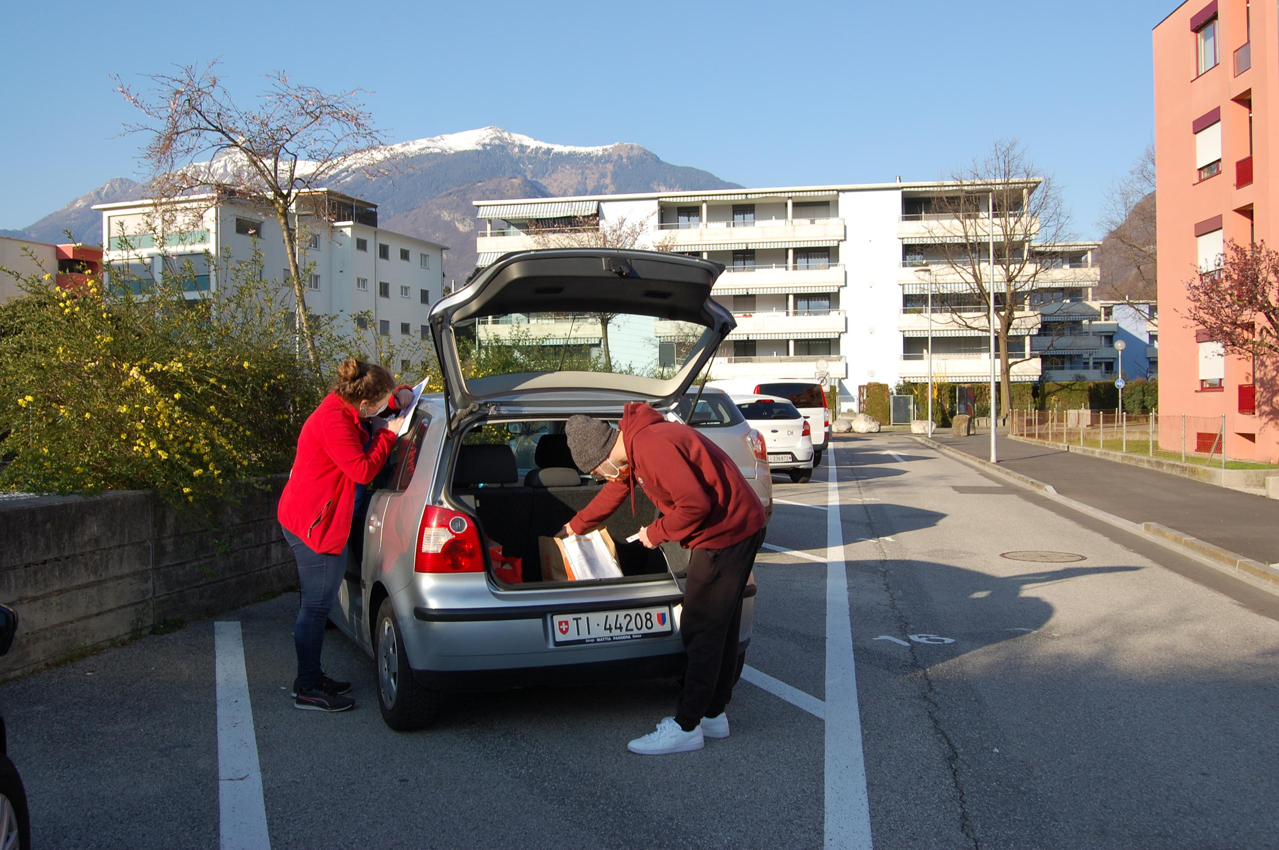 Zwei Junge beladen ein Auto