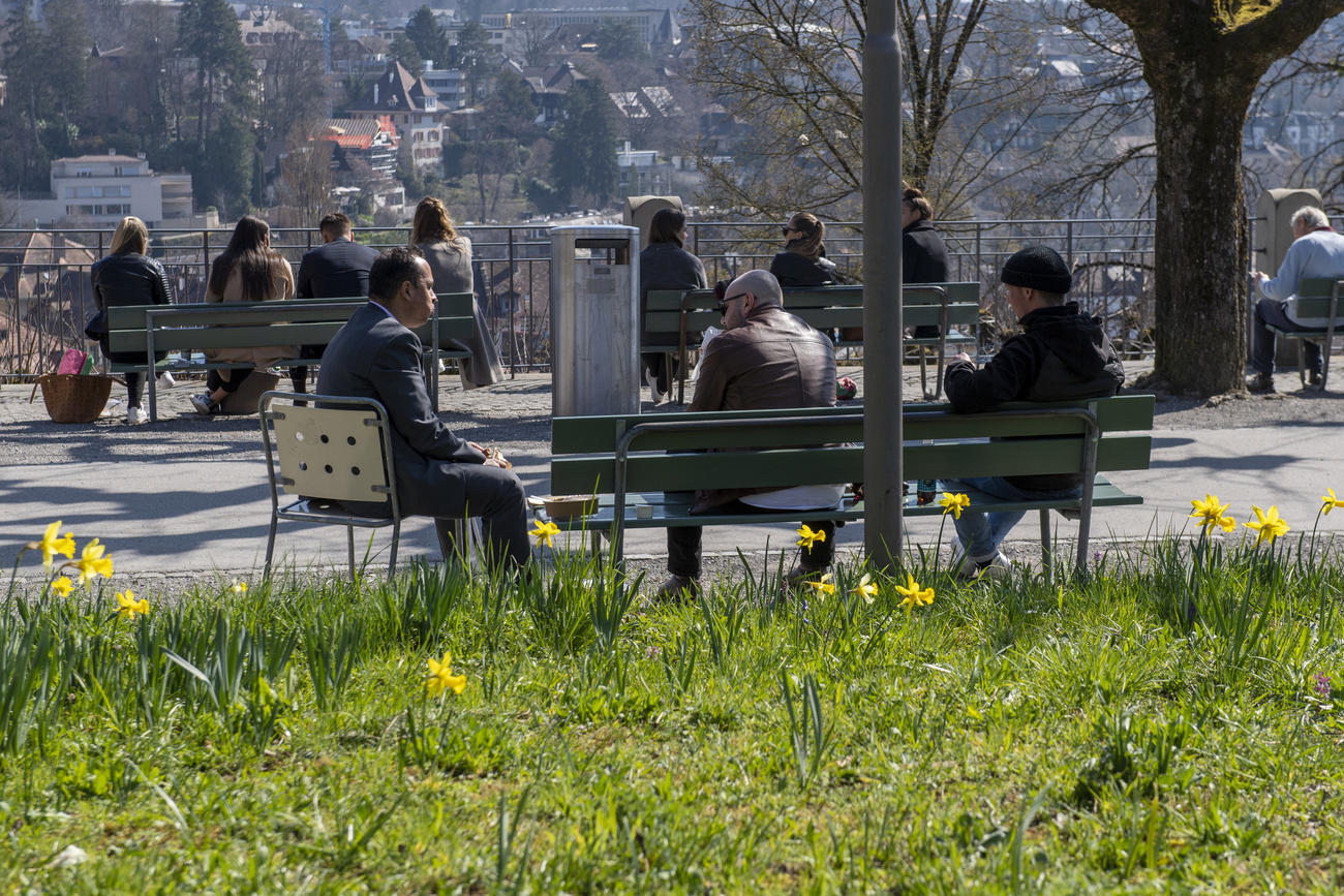 Gente seduta su delle panchine a Berna. Foto del 18 marzo.