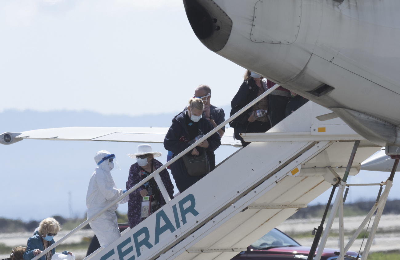 Passengers from the Grand Princess cruise ship are assisted boarding a charter plane