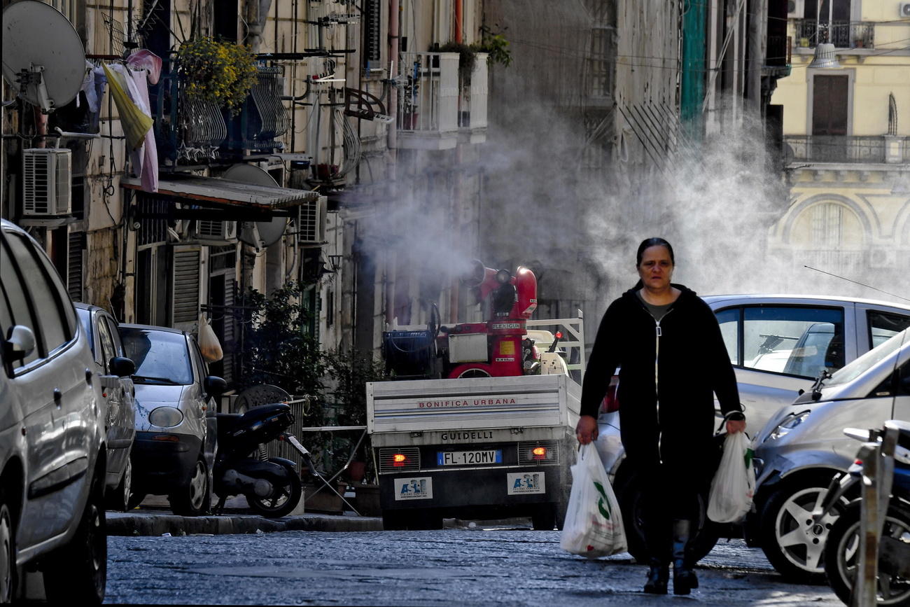 Una donna nel quartiere Forcella nel centro di Napoli con due borse della spesa.