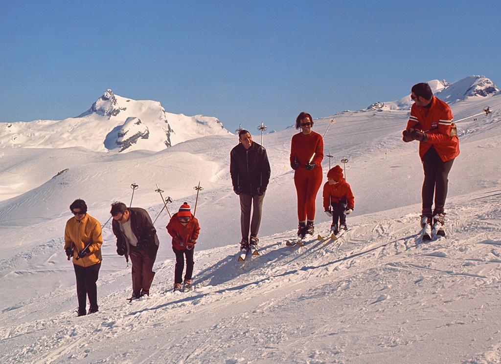 Eine Skischule in einer Reihe auf der Piste.