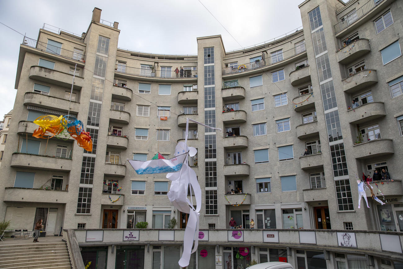 Altos edificios con gente asomada a los balcones