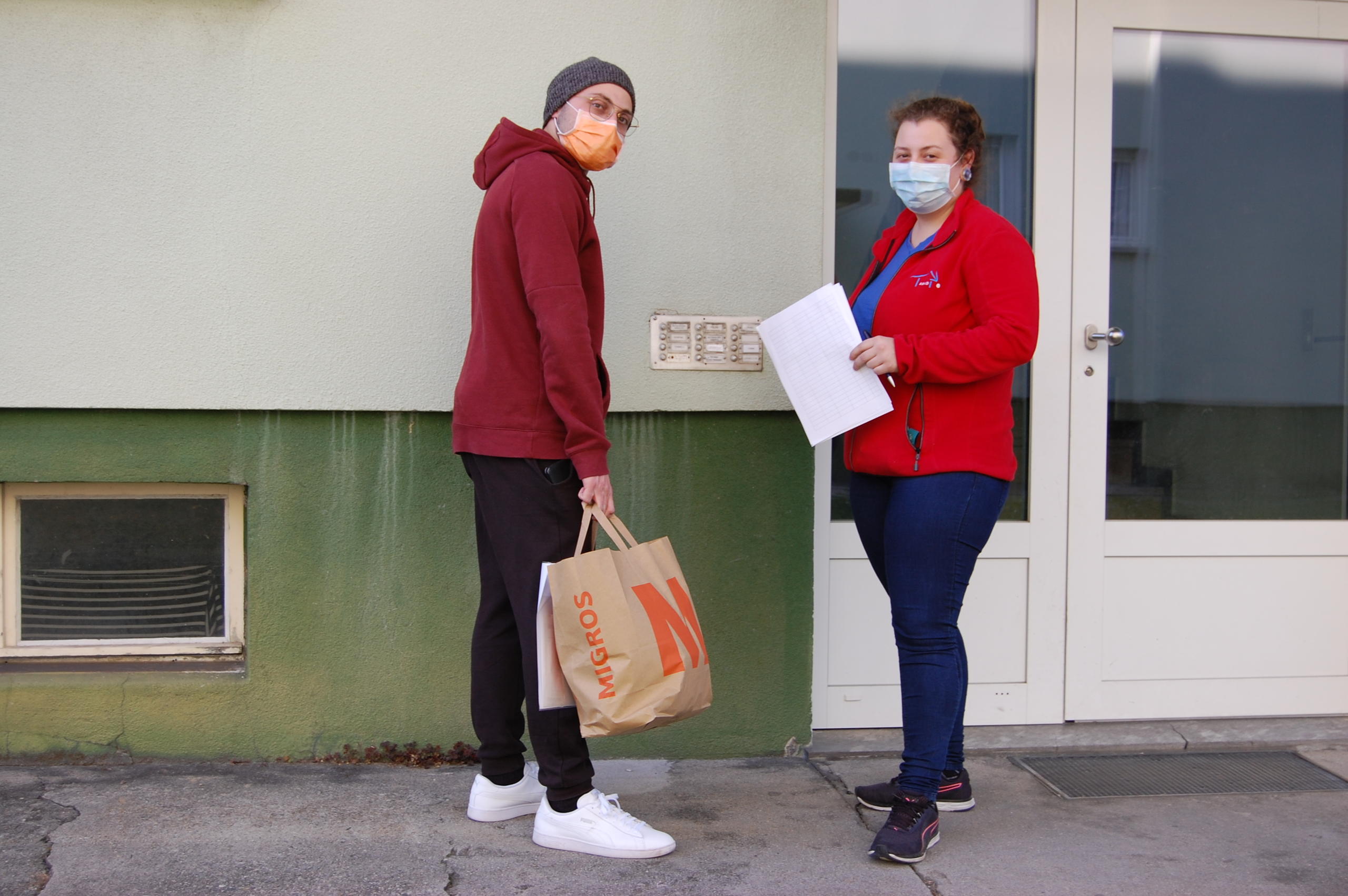 Dos personas guardan distancia, una lleva mascarilla