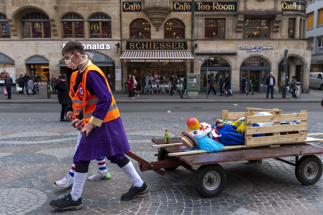 Carnival goers wearing protection masks pulling a cart