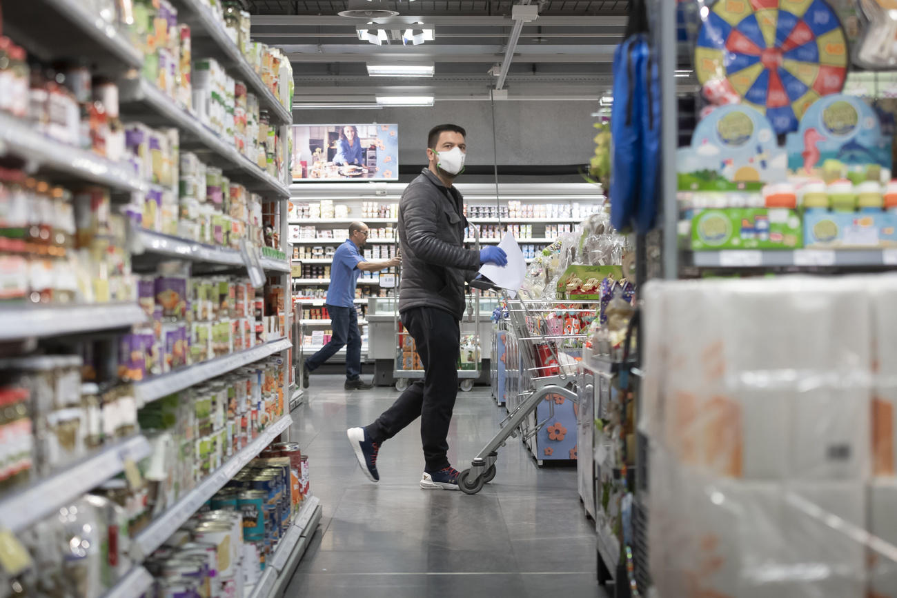 homem às compras com máscara de proteção