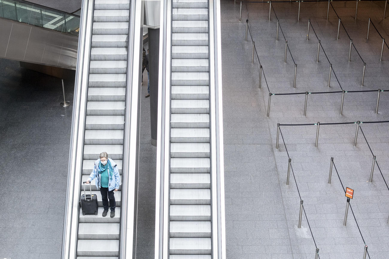 Eine Reisende mit schützt sich mit einer Maske vom Coronavirus am Flughafen Zürich.