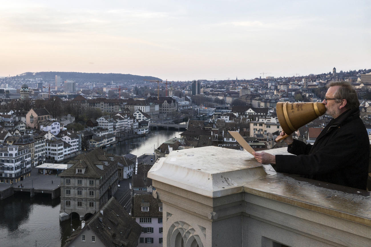 Un hombre habla desde la torre de la catedral urilizando un gran embudo como altavoz