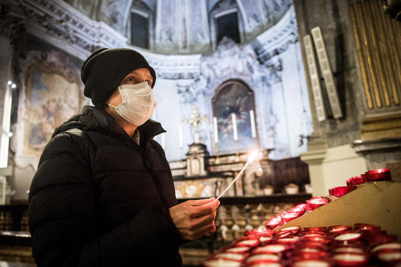 uomo con la mascherina con in mano una candela