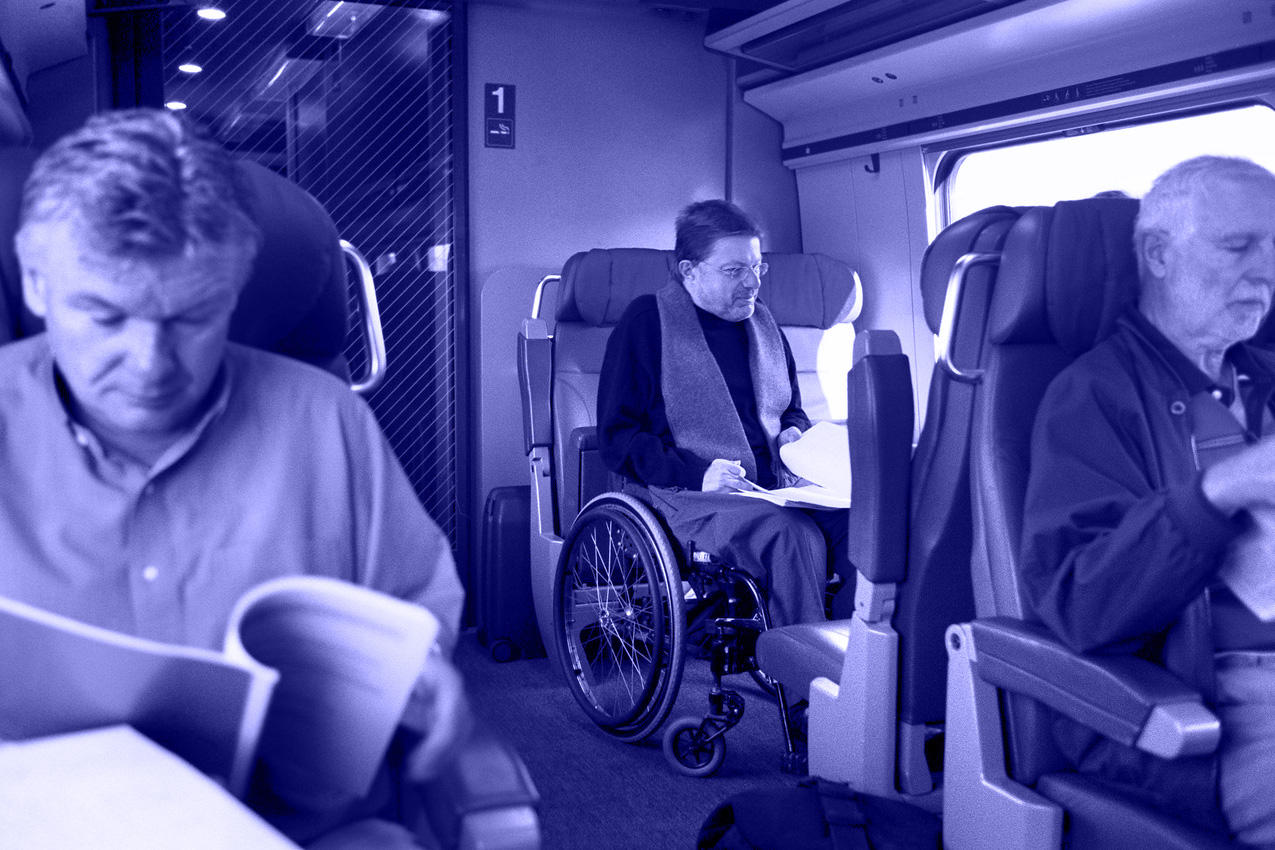 男性が車いすでスイス国内の列車を利用しているところ。列車内の1等席車いす用の席。