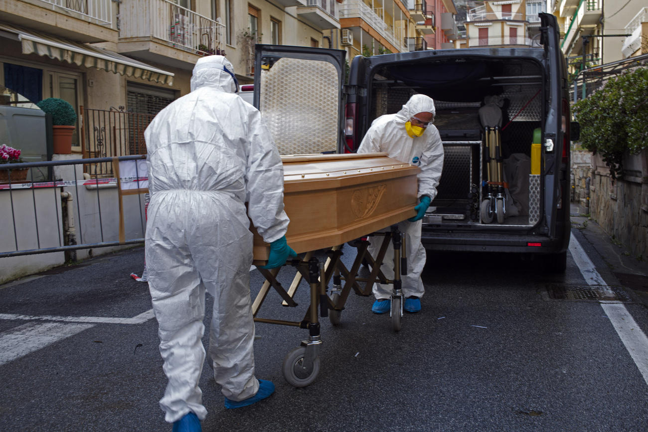 Two men carry a coffin