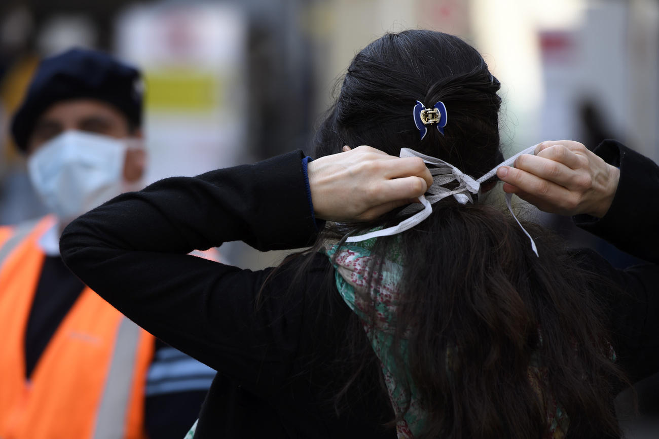 une femme met un masque de protection