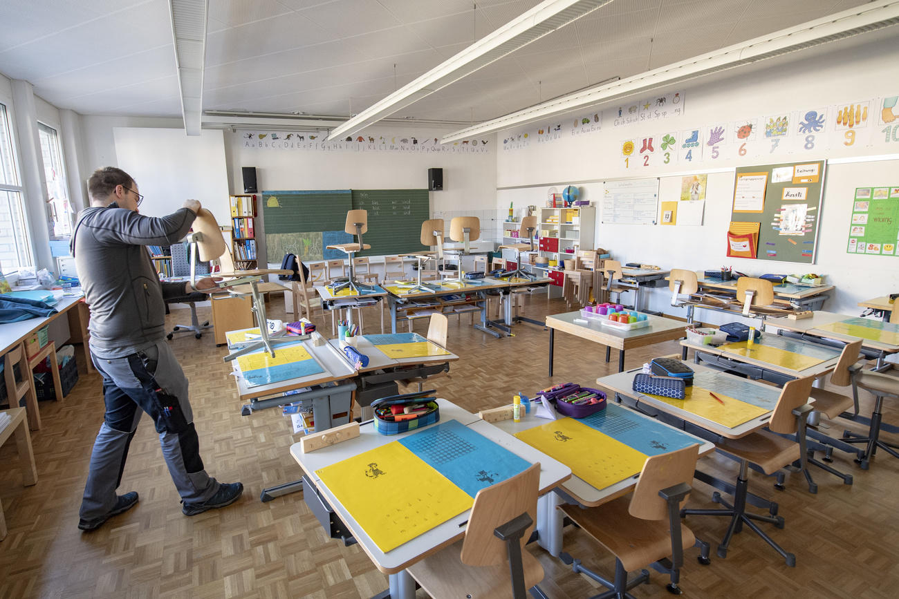 Ein Hausabwart bei der Arbeit im leeren Schulzimmer der Primarschule Tellenmatt in Stans, Nidwalden.