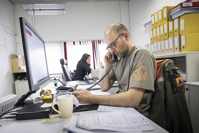 En una oficina, dos personas hablan por teléfono