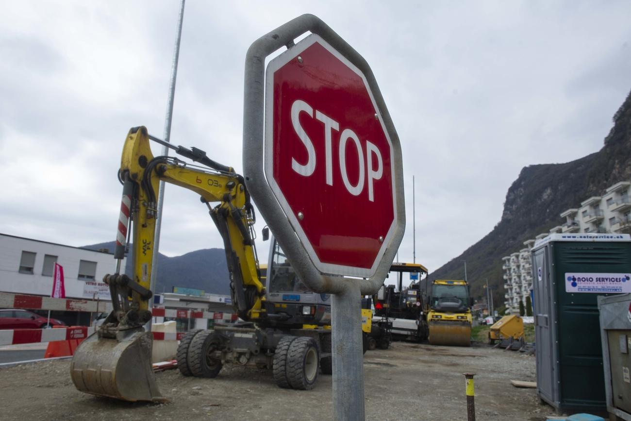 Il cartello stradale Stop proprio davanti a un cantiere fermo in Ticino.