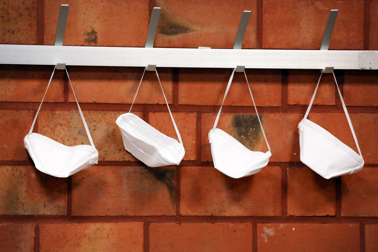 Schutzmasken hangen an Garderobe.